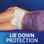 A woman in a purple t-shirt is lying down while wearing TENA underwear. A text underneath the image reads "Lie down protection"