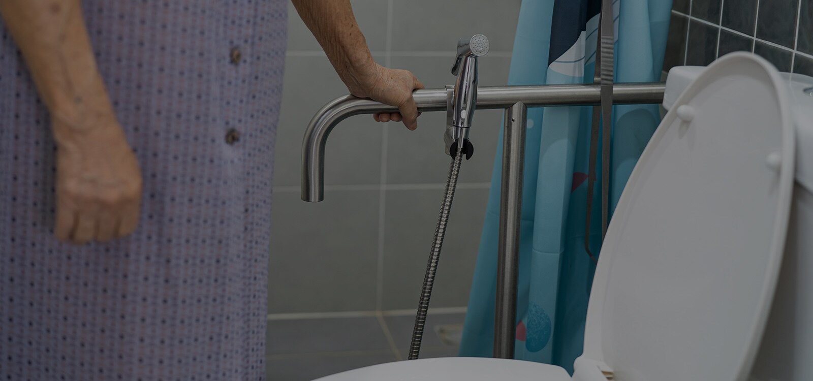 Mujer mayor apoyanda en una barandilla mientras que va al baño
