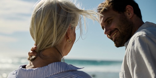 Caregiver con una donna sorridente sulla spiaggia