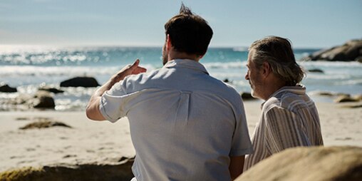 Cuidador com uma mulher a olhar para o mar e a sorrir