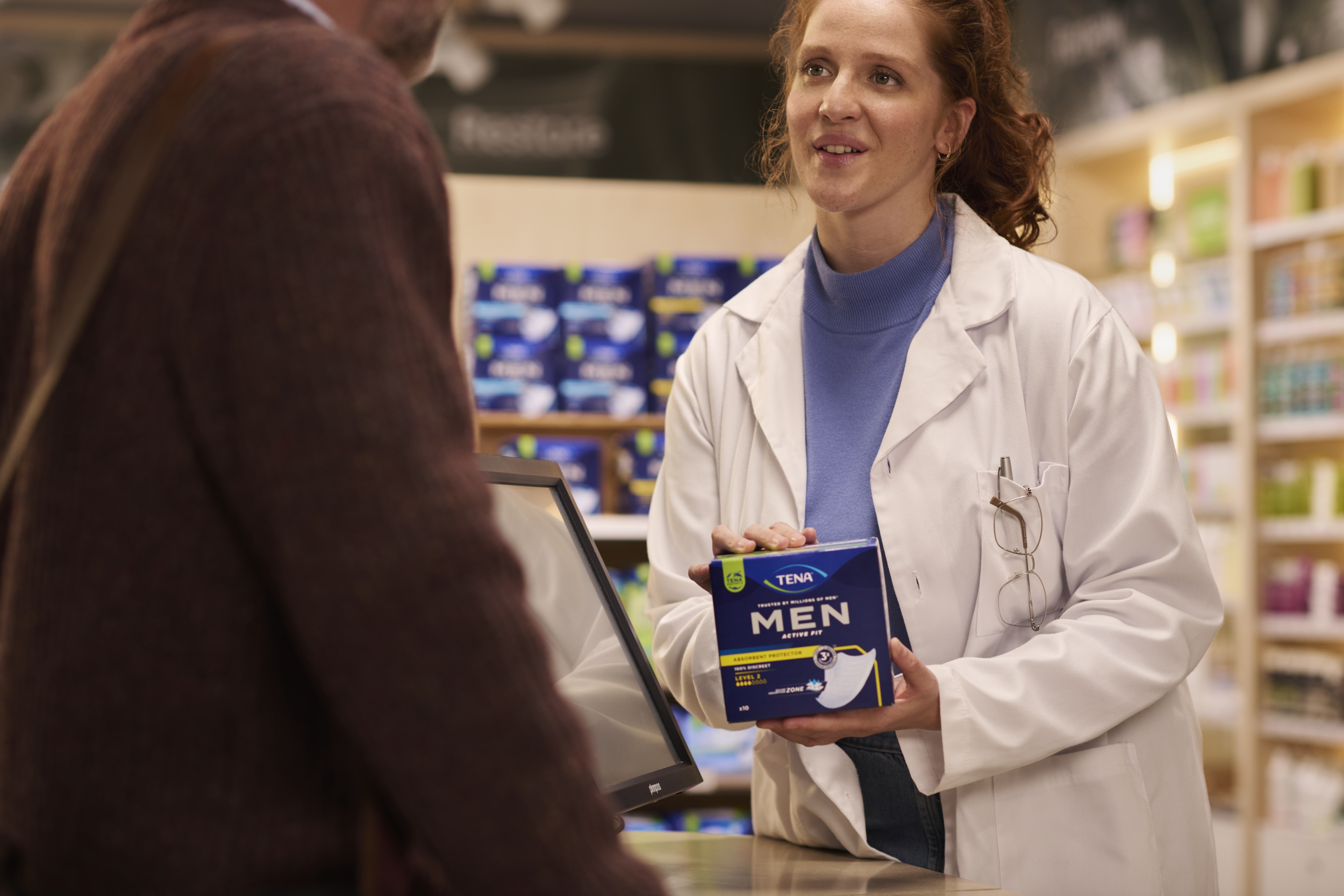 TENA Professionals Men Lifestyle Pharmacy Man with Pharmacist V3 Landscape                                                                                                                                                                                                                                                                                                                                                                                                                                          