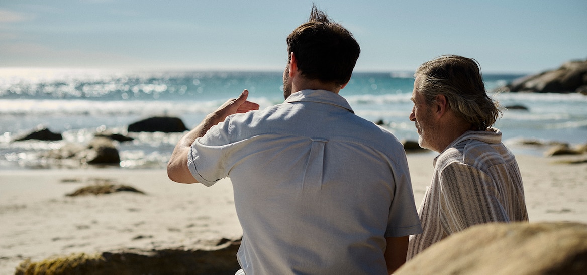 Caregiver con una donna che guarda il mare sorridendo