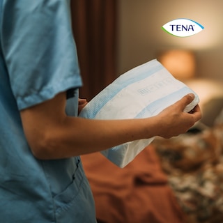 Holding TENA Proskin Slip product in hands