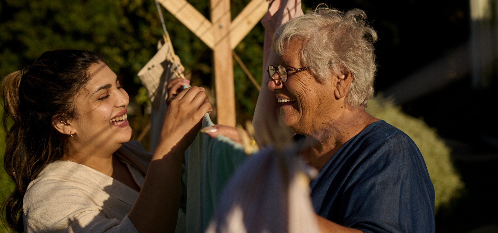 Younger woman helping an older woman in bed 