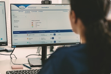 A professional caregiver reads statistics and reports generated by the TENA SmartCare Change Indicator. These can be used to adapt care as residents’ needs change.