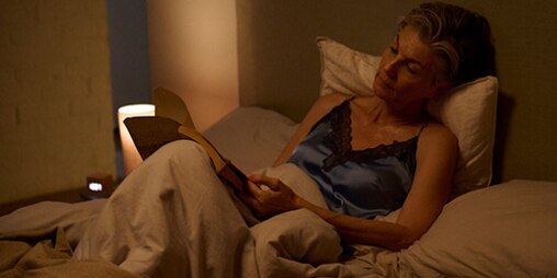 Eine Frau liest ein Buch im Bett