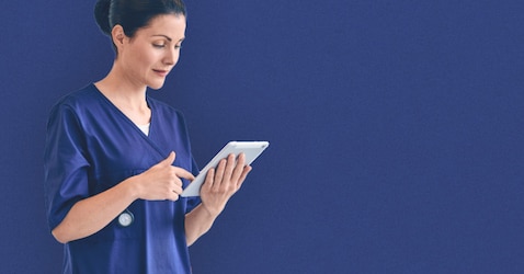 A female professional caregiver using a tablet device 