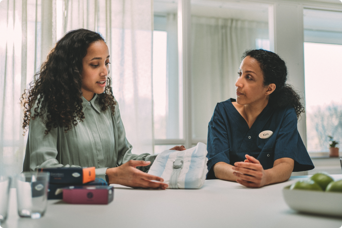 Un représentant TENA SmartCare montre à un soignant professionnel comment fonctionne TENA SmartCare Change Indicator.