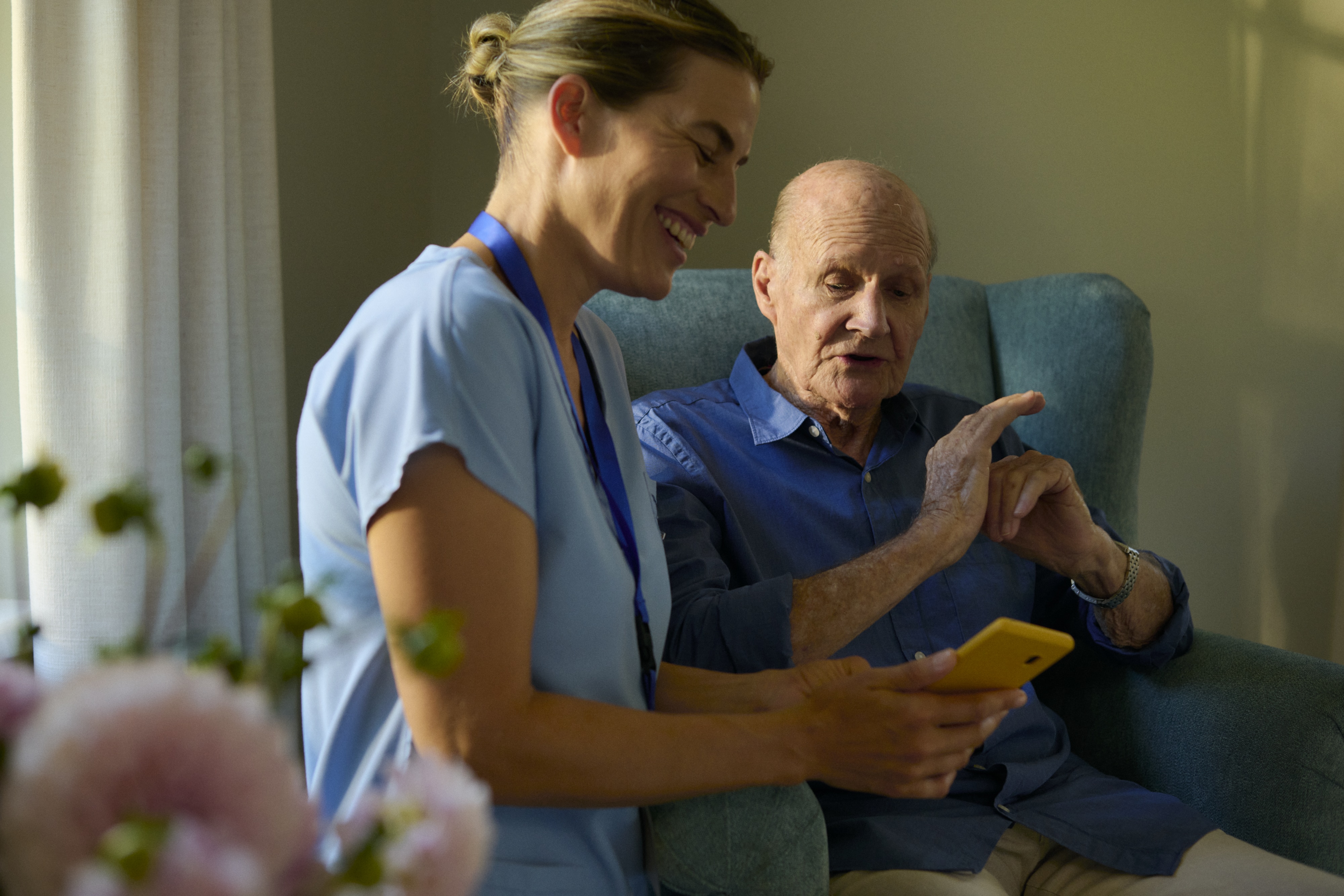 Nusring home care giver looking at smart phone