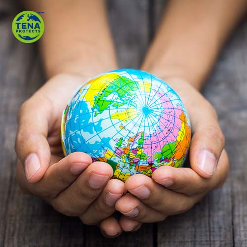 Les mains d'un enfant tenant un petit globe terrestre. Le logo TENA Protects apparaît dans le coin supérieur gauche.