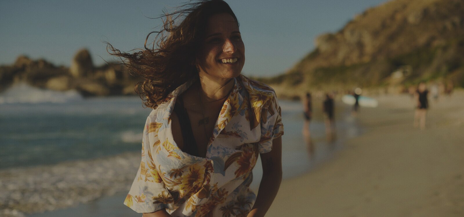 Una mujer feliz andando por la playa