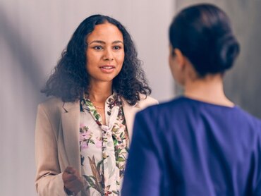 Two women facing each other in conversation.