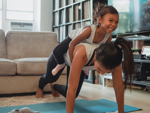 Woman playing with child during exercise routine.