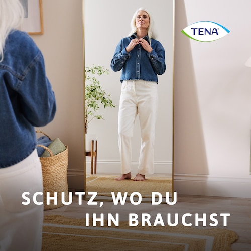 Frau vor einem Spiegel stehend, vollständig bekleidet, mit der Bildunterschrift „Schutz, wo du ihn benötigst“