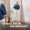 Frau vor einem Spiegel stehend, vollständig bekleidet, mit der Bildunterschrift „Schutz, wo du ihn benötigst“