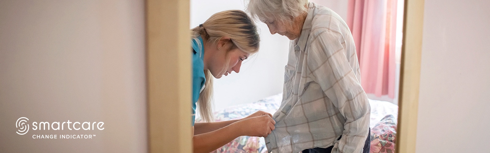 Nurse helping an elderly female resident getting dressed