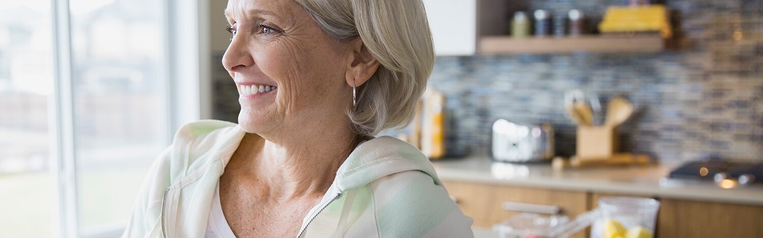 Kobieta w kuchni nosząca majtki chłonne, czująca komfort i pewność siebie.