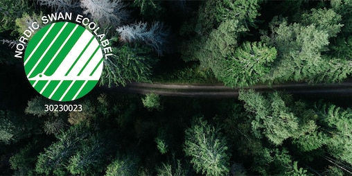 A bird’s eye view of a coniferous forest, with a path running through it. Superimposed over the image is the green and white Nordic Swan logo, depicting a swan in flight.
