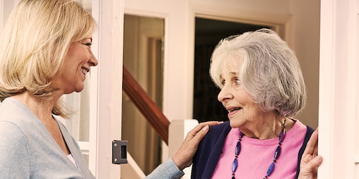 Fiatal nő üdvözöl egy idős nőt – Az első lépések az ápolóvá válás útján