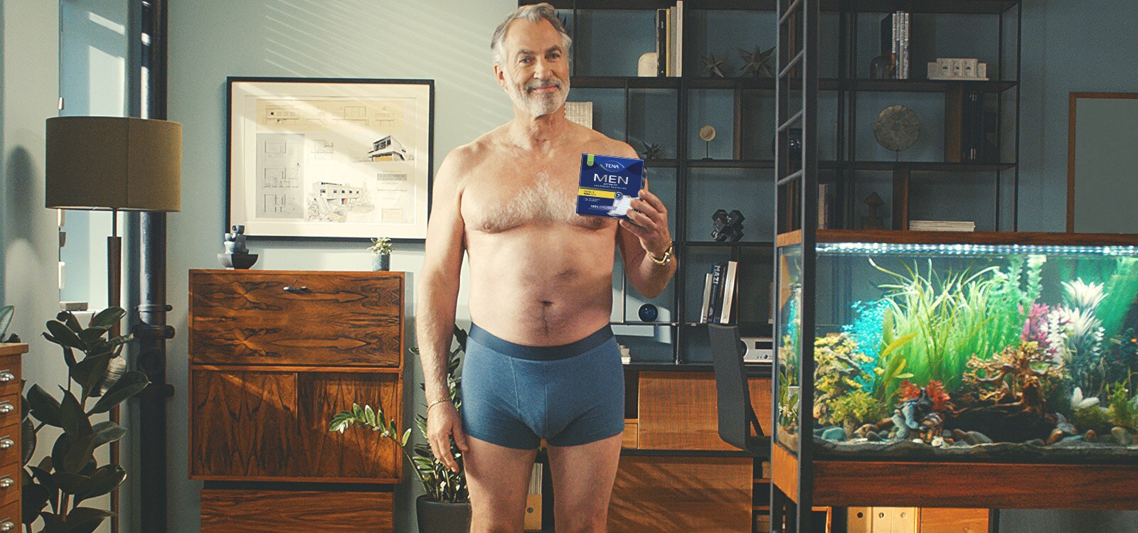 Pewny siebie, zrelaksowany 50-latek pozuje w bieliźnie TENA Men. 