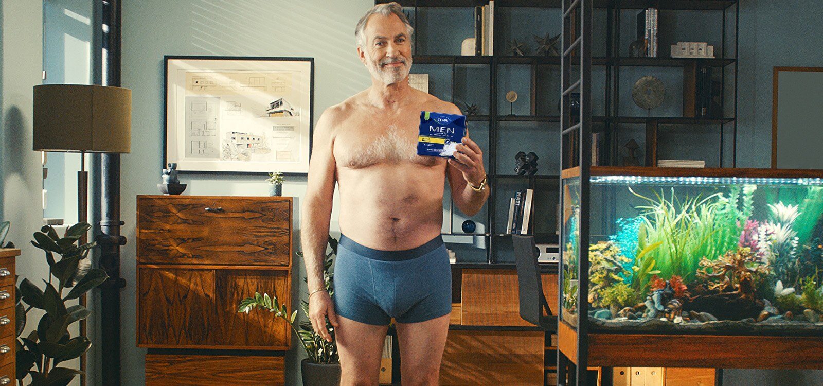 Pewny siebie, zrelaksowany 50-latek pozuje w bieliźnie TENA Men. 