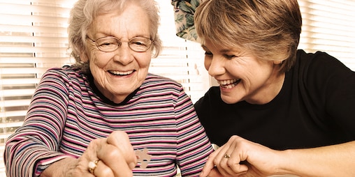 Genç kadın ve yaşlı kadın birlikte bir yapboz yapıyor - hasta olan yakınınız ile yapabileceğiniz aktiviteler