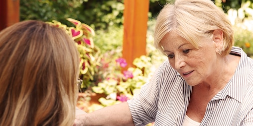 Femme âgée assise avec une femme plus jeune – optimiser les dépenses de soins de votre proche