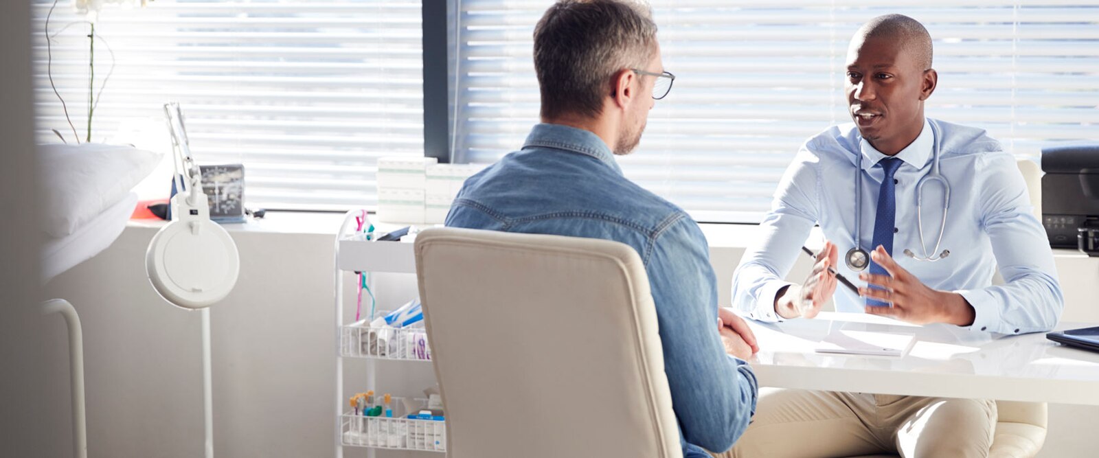 Dokter spreekt met patient in behandelkamer