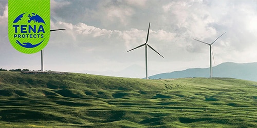 Three wind turbines on the crest of a green hill. The TENA Protects logo.