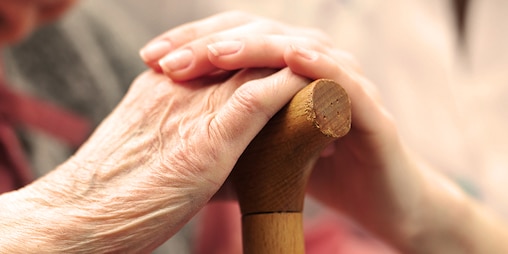 Žena v seniorskom veku sa drží za ruku s mladšou ženou – podpora miestnych organizácií a charity
