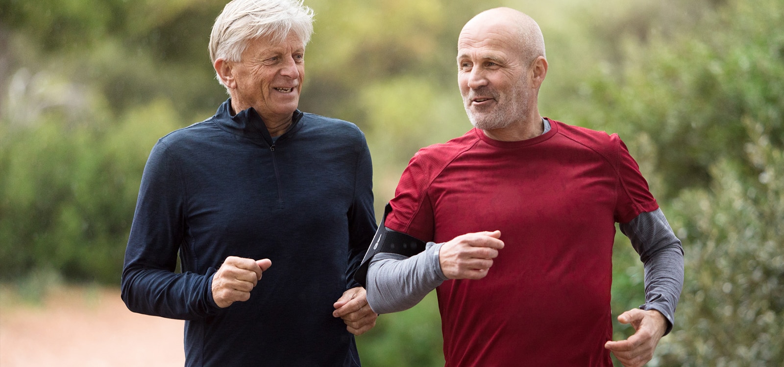 Doi bărbați cu vârste cuprinse între 50 și 60 de ani care aleargă
