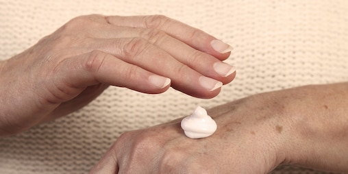 Äldre kvinna applicerar fuktkräm – hålla din närståendes hud frisk