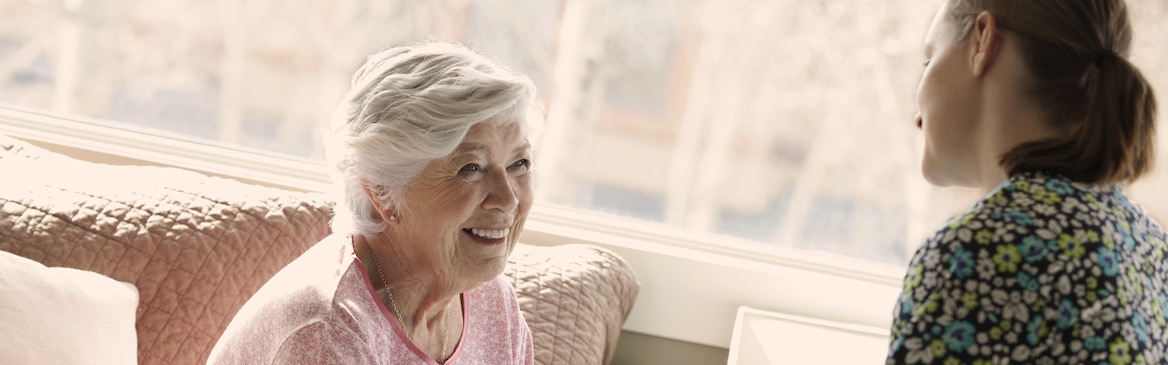 Yngre kvinna och äldre kvinna samtalar – läs om vad det är som orsakar inkontinens