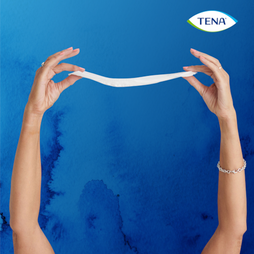 Osoba pokazuje koliko je tanak uložak za inkontinenciju TENA Lady Slim Extra