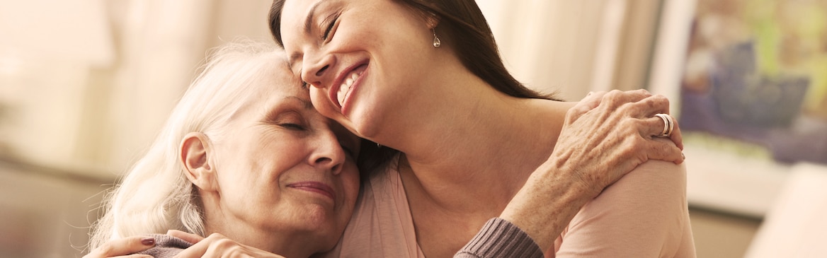 Mladá žena objímá starší ženu – jak se vypořádat s chřadnoucím zdravím vašich blízkých