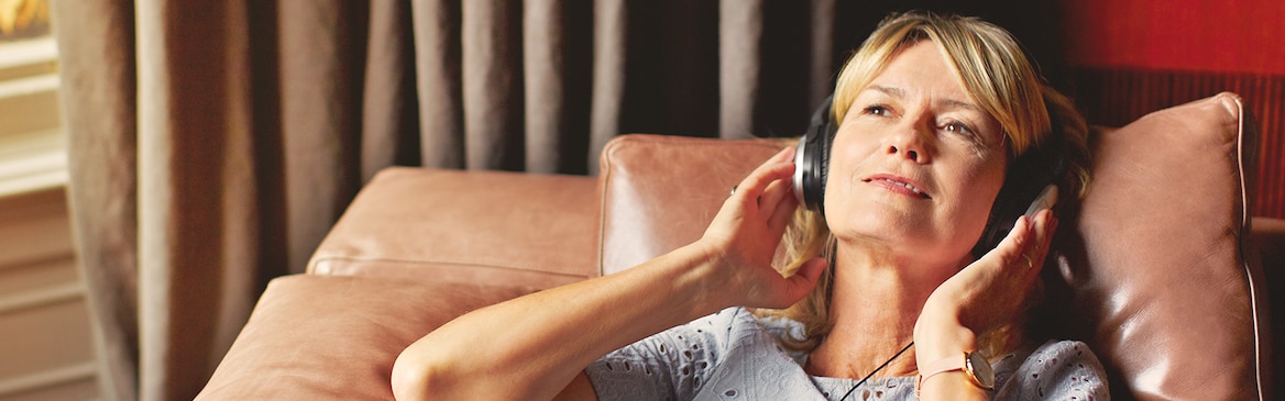 Ženska se sprošča in posluša glasbo – namigi za obvladovanje stresa pri negi