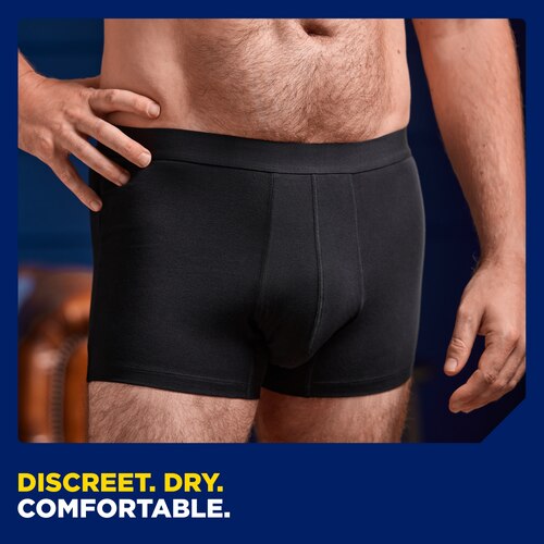 Close up image of a man's lower body seen from the front wearing the TENA washable underwear. The caption at the bottom of the image says "Discreet.Dry.Comfortable".