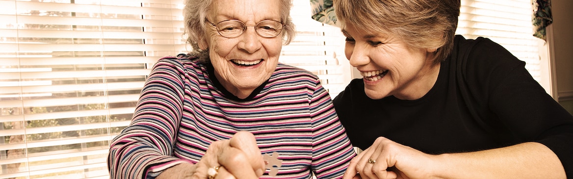 Genç kadın ve yaşlı kadın birlikte bir yapboz yapıyor - sevdiğiniz kişi ile yapabileceğiniz aktiviteler