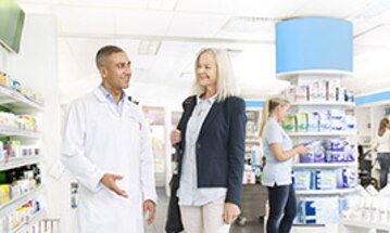 A man and a woman standing in a pharmacy
