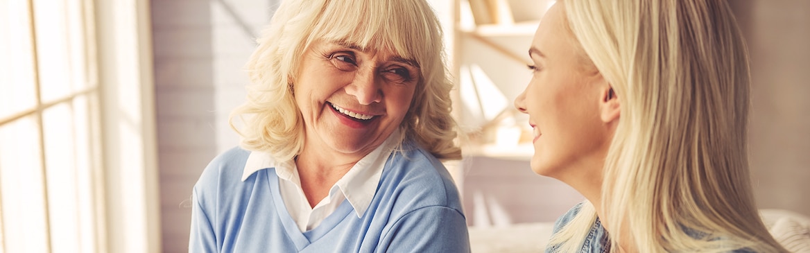 Senhora mais velha a rir com senhora mais jovem – formas de ajudar o seu ente querido a lidar com a incontinência