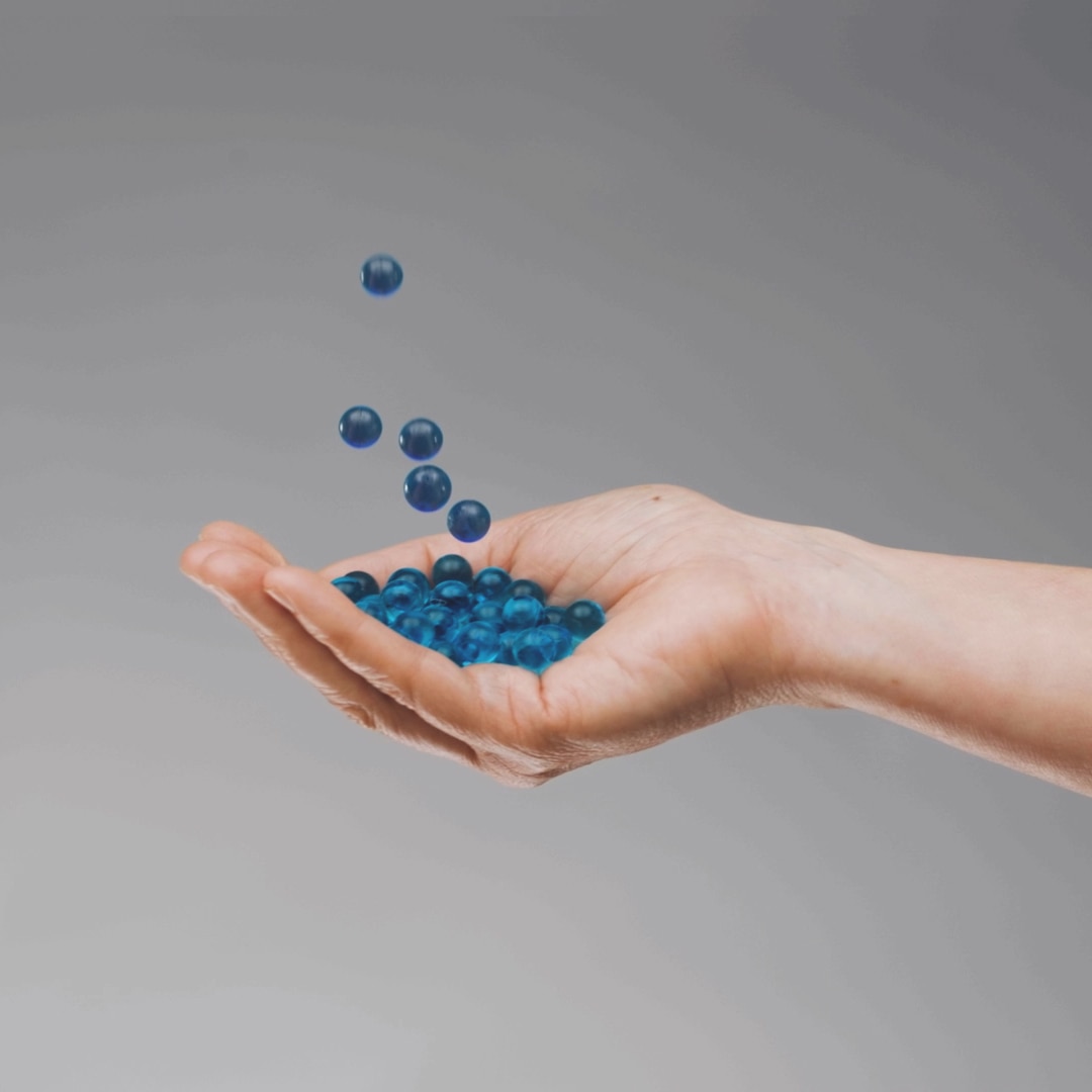 A hand holds animated water droplets. The droplets are seen to rise up into the air one by one.