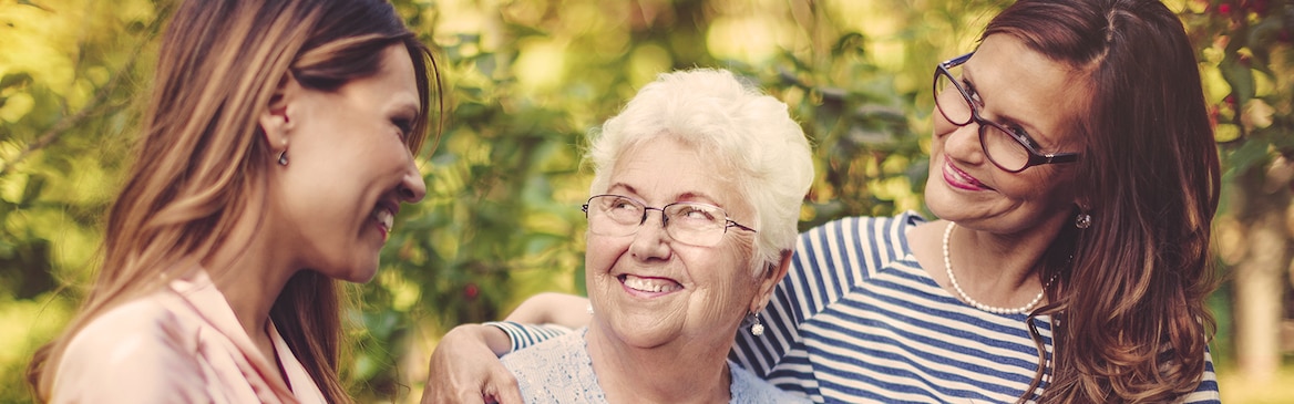 Senhora idosa com duas senhoras mais jovens – dividir o volume de trabalho da prestação de cuidados
