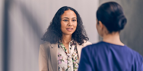 An elderly woman pushes a young boy on a tire swing.