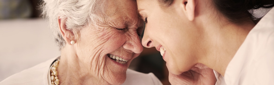 Oudere dame en jongere vrouw, lachend – hoe dementie van invloed is op uw naaste