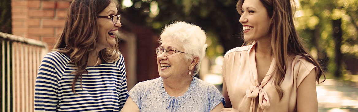 Oudere vrouw met twee jongere vrouwen buiten – hoe ouder worden van invloed is op onze mobiliteit
