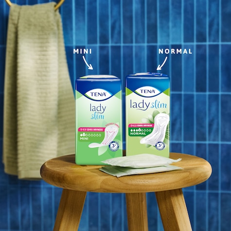 Zbliżenie na stolik na którym znaduje się opakowanie wkłade TENA Lady Slim Mini oraz TENA Lady Slim Normal