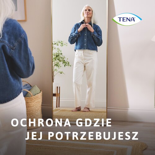 Kobieta stojąca przed lustrem w jasnych spodniach pewna ochrony przed NTM