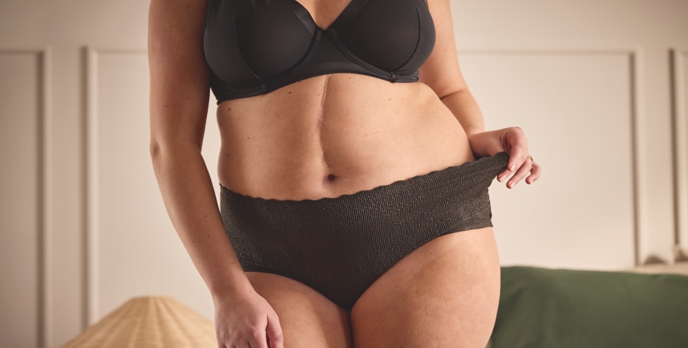 Vrouw demonstreert de nauwsluitende pasvorm en het discrete ontwerp van TENA Silhouette voor comfortabele bescherming.