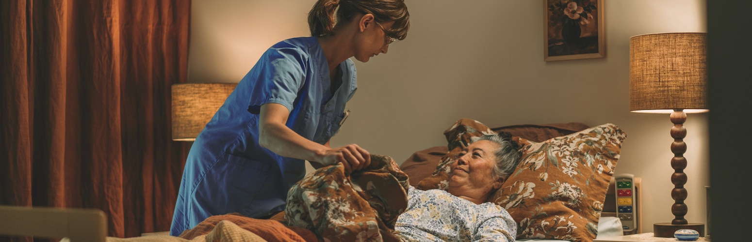 Carer helping a resident in bed