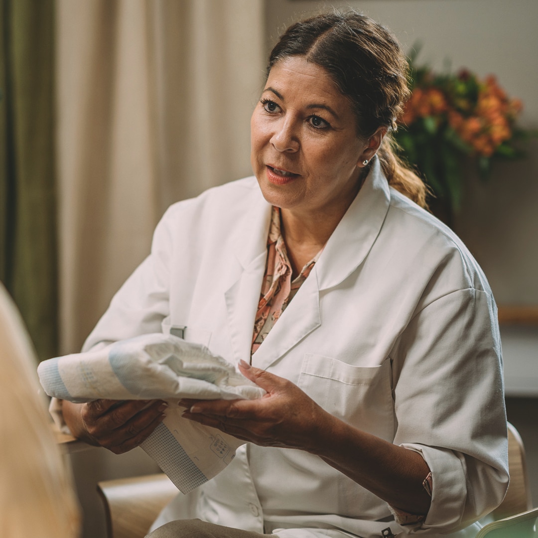 A carer holding a TENA product in a nursing home environment